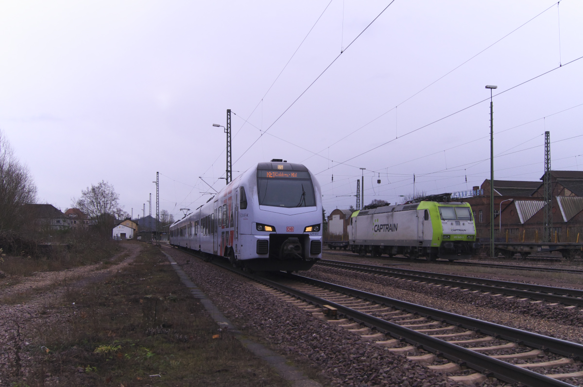 429 102 rauscht gerade als RE Saarbrücken - Koblenz durch den Bahnhof Bous Saar. Im Hintergrund Captrain 185 549 und die Gebäude der ehemaligen Mannesmann Röhrenwerke, heute Stahlwerk Bous. Bahnstrecke 3230 Saarbrücken - Karthaus am 04.02.2017.