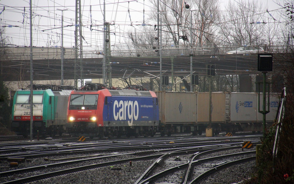 482 023-9 von SBB Cargo kommt aus Richtung Köln,Aachen-Hbf,Aachen-Schanz mit einem  Containerzug aus Novara(I) nach Genk-Zuid Haven(B) und fährt in Aachen-West ein. Aufgenommen vom Bahnsteig in Aachen-West. 
Bei Nieselregen und Sturm am Morgen vom 1.2.2016.
