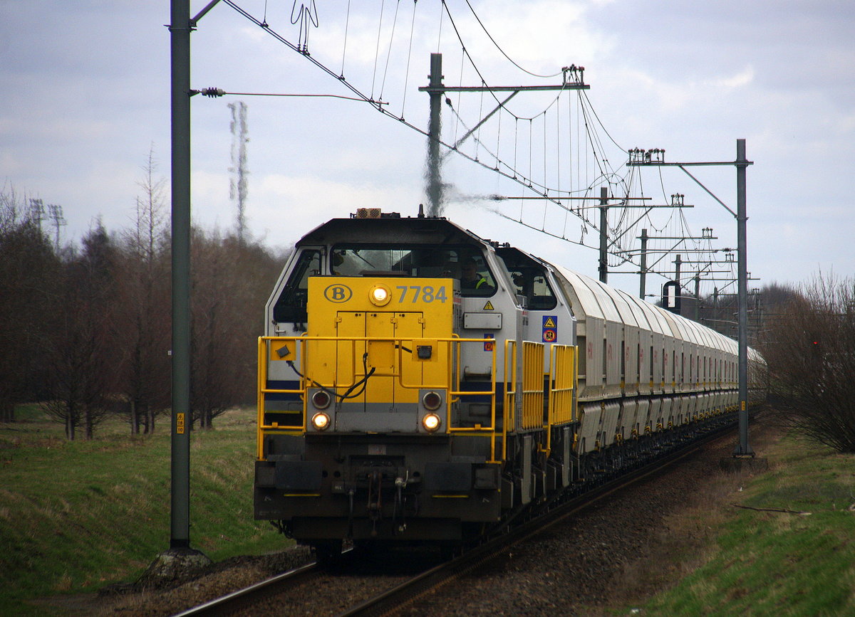 7784,7867 beide von der SNCB  kommen durch Geleen-Lutterade(NL) mit einem langen Kalkleerzug aus Millingen(D) nach Yves-Gomezee(B) und fahren in Richtung Maastricht(NL).
Aufgenommen in Geleen-Lutterade(NL). 
Bei Sonne und Wolken am Kalten Mittag vom 28.2.2017.