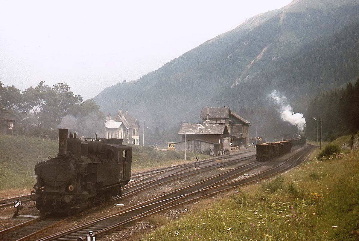 97.203 und eine weitere 97 haben im August 1975 einen beladenen Halbzug vom Bahnhof Erzberg nach Präbichl gebracht. Die 97.203 setzt sich jetzt an das Zugende, während die andere 97 die Erzwagen an die bereits bereitstehenden Wagen rangiert.