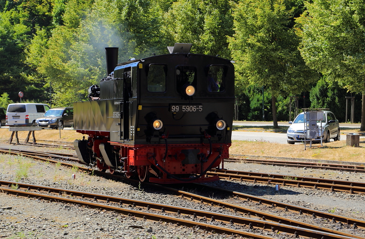 99 5906 am 07.07.2018 auf Umsetzfahrt im Bahnhof Alexisbad. Sie befindet sich jetzt bereits wieder auf Gleis 2, wird aber, bevor sie den dort wartenden Jubiläumssonderzug der IG HSB übernimmt, noch am Wasserkran Station machen um ihre Wasservorräte aufzufüllen und vom Lokpersonal durchgesehen und abgeschmiert zu werden.