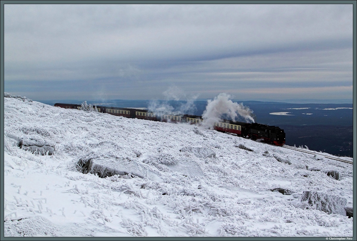 99 7234-0 hat mit dem P 8930 nach Wernigerode soeben den Bahnhof Brocken verlassen und passiert die frostige Winterlandschaft nahe dem Gipfel. (27.12.2014)