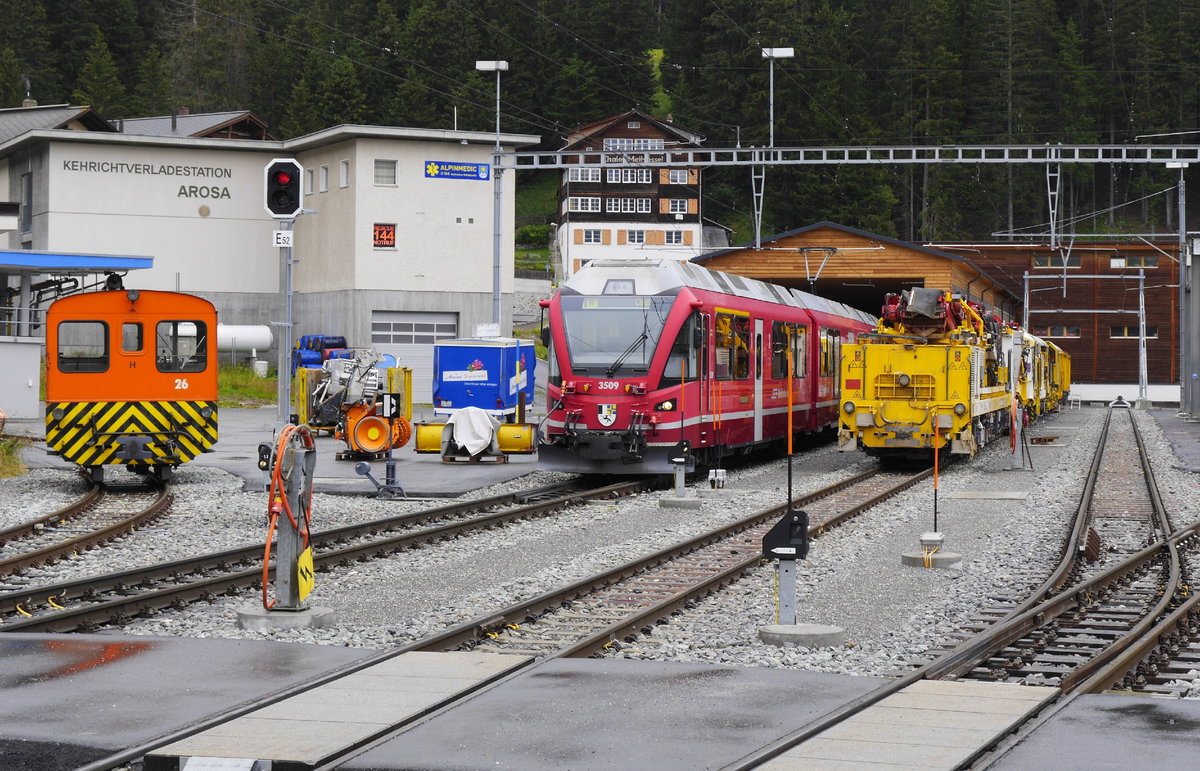 ABe 8/12 3509 im Abstellbereich/Güterabfertigung in Arosa, eingerahmt vom Traktor Nr. 26 und einer Gleisbaumaschine, 12.8.16.