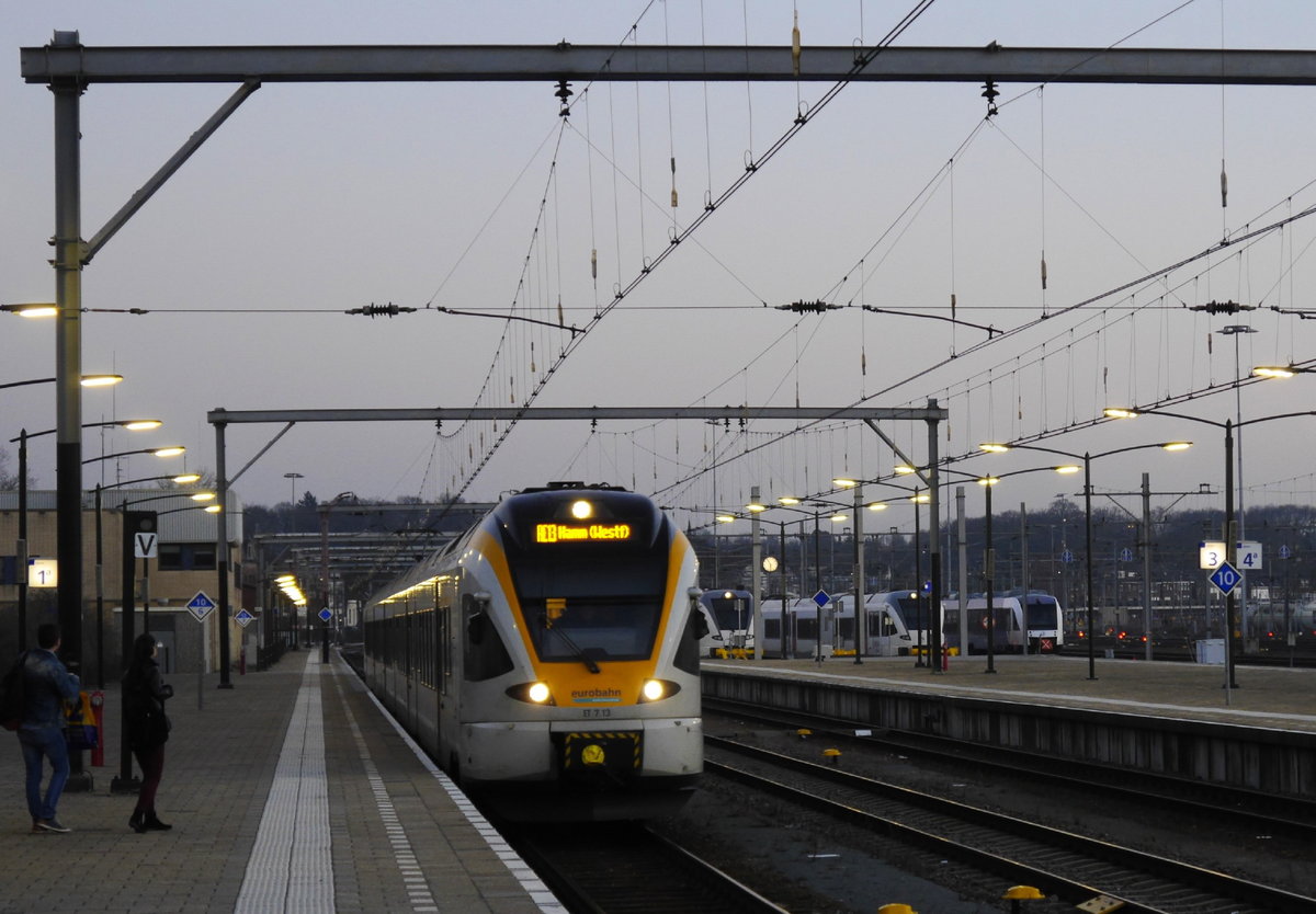 Abendstimmung in Venlo:  Eurobahn-ET 7.13 fährt von der Grenze her ein.  In der Abstellanlage am 2. Bahnsteig stehen zwei GTw 2/8 und ein LINT 41 der Arriva-NL (ex-Veolia). Aufnahme: 14.2.17, kurz vor 18 Uhr.