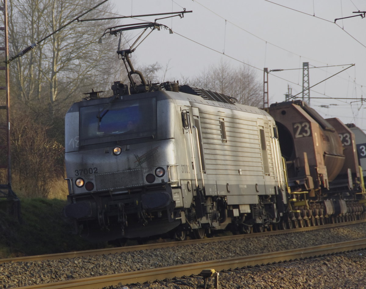 Akiem 37002 legt sich mit den leeren Flüssigeisentorpedowagen in die Kurve zwischen Bous und Ensdorf Saar. Bahnstrecke 3230 Saarbrücken - Karthaus am 28.12.2016