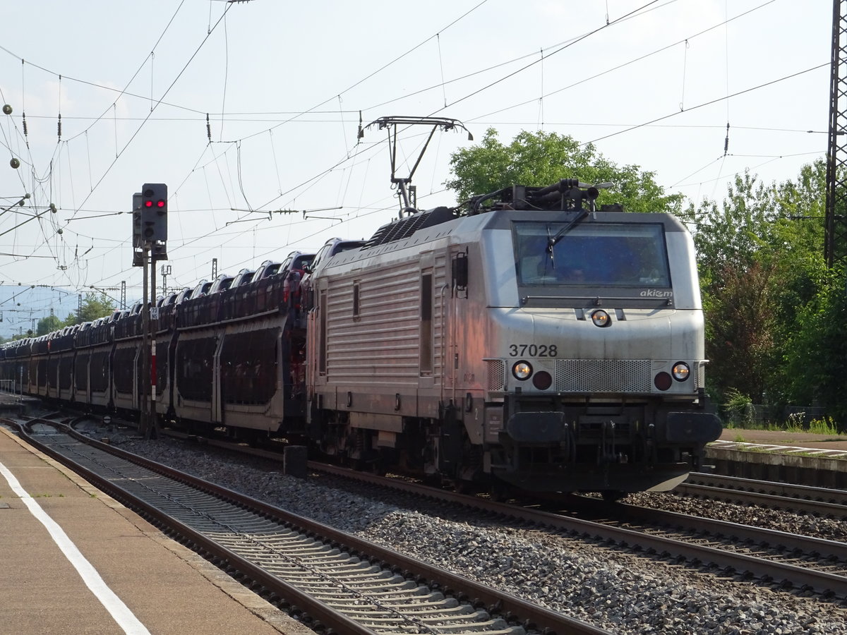Akiem 37028 mit einem Autozug im Bahnhof Denzlingen. Aufgenommen im Juli 2018.