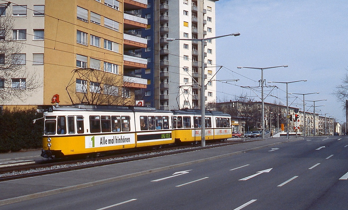 Als der GT4 743 und ein weiterer GT4 am 25.02.1990 die Haldenrainstraße von Freiberg hinunter in Richtung Zuffenhausen fahren, ist fast alles schon für die Stadtbahn-Betriebsaufnahme vorbereitet, nur die Normalspurgleise liegen noch nicht. Hinweis zum Fotostandpunkt: Hier bin ich mir nicht ganz sicher, Anhaltspunkte sind die im Hintergrund sichtbare Stadtbahn-Haltestelle und angeschnitten ganz rechts der Turm der Kirche Zur heiligen Dreifaltigkeit.