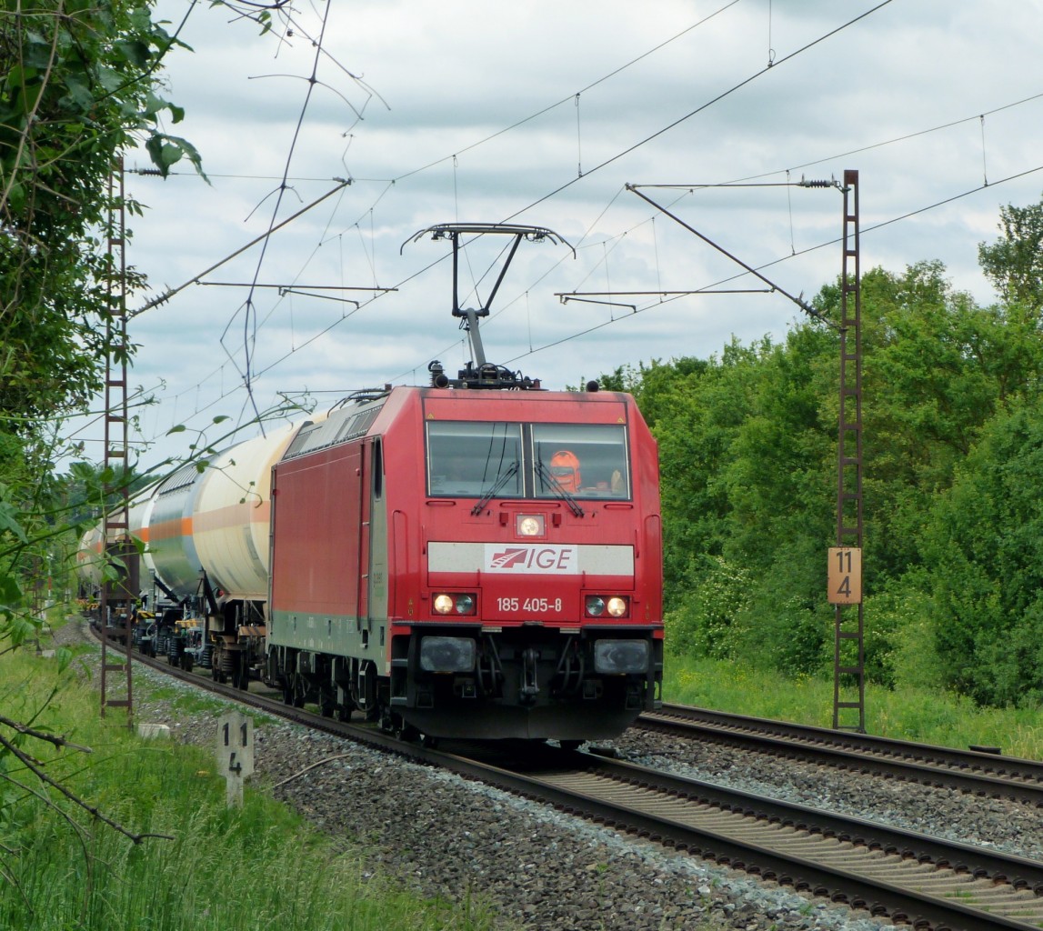 Als die Lok hinter der Kurve auftauchte, dachten wir zuerst an eine normale DB 185.
Doch auf den zweiten Blick erschien der DB Keks etwas komisch. So sahen wir das es sich bei der 185 405 um eine Lok der IGE handelte. Und damit noch nicht genug: Desweiteren war sie eine der Loks, die noch die Green Cargo Werbung besaß.
So durchfährt die Lok am 24.5.14 das Maintal und wurde von mir bei Thüngersheim fotografiert.