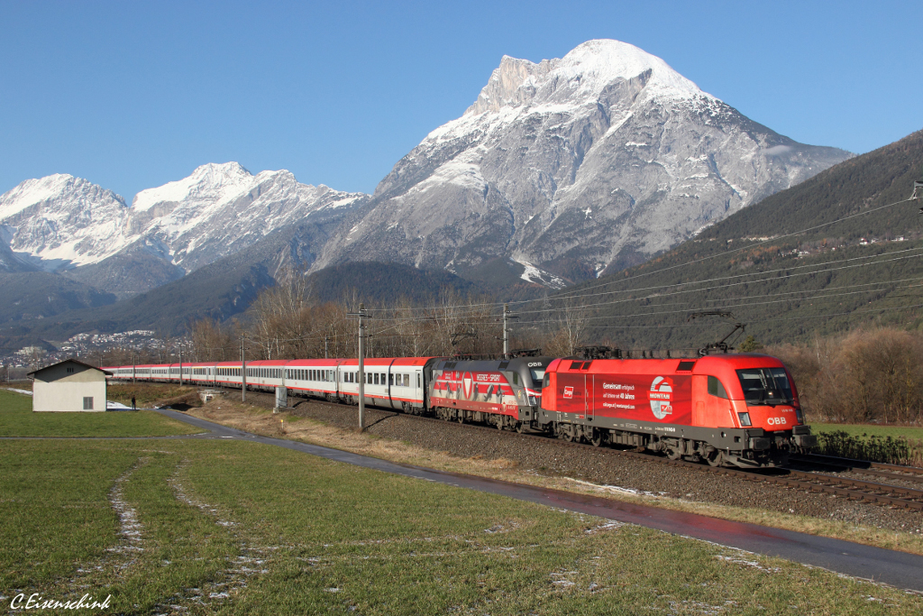 Am 01.12.13 bespannten die 1116 143  Montan Sped  und die 1116 138  Heeressport  den OIC 867  Österreich liest  von Bregenz nach Wien Westbahnhof. Hier ist das bunte Gespann bei Flaurling zu sehen.