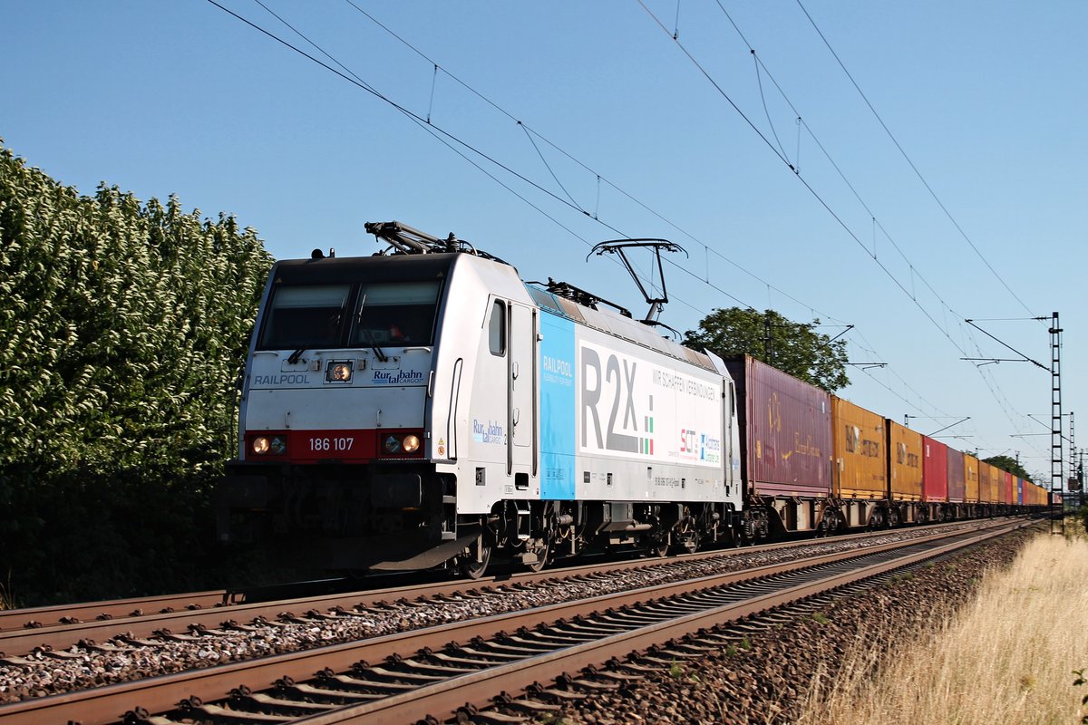 Am 10.07.2015 bespannte Railpool/BLS Cargo 186 107  Ruhrtalbahn CARGO/R2X  einen Containerzug nach Holland, als sie bei Hügelheim in Richtung Freiburg fuhr. Zum Zeitpunkt der Aufnahme war die 186 107 noch nicht sehr lange bei BLS Cargo, weshalb sie noch die Werbung ihres Vormieters getragen hatte.