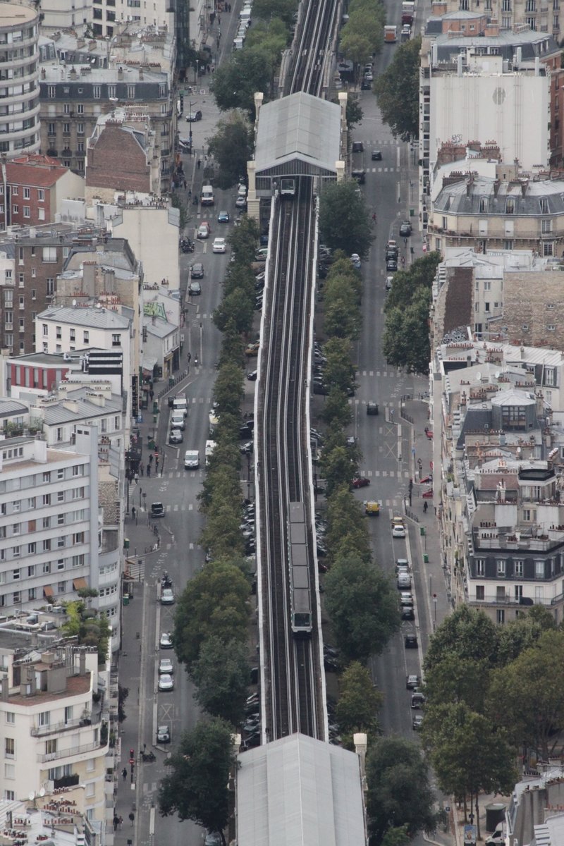 Am 10.08.2016 ist ein Zug der Metro Paris als M6 auf der Hochbahnstrecke zwischen den Stationen Sevres-Lecourbe und Cambronne in Richtung Seine unterwegs. Blick von der Aussichtsplattform des Tour Montparnasse.