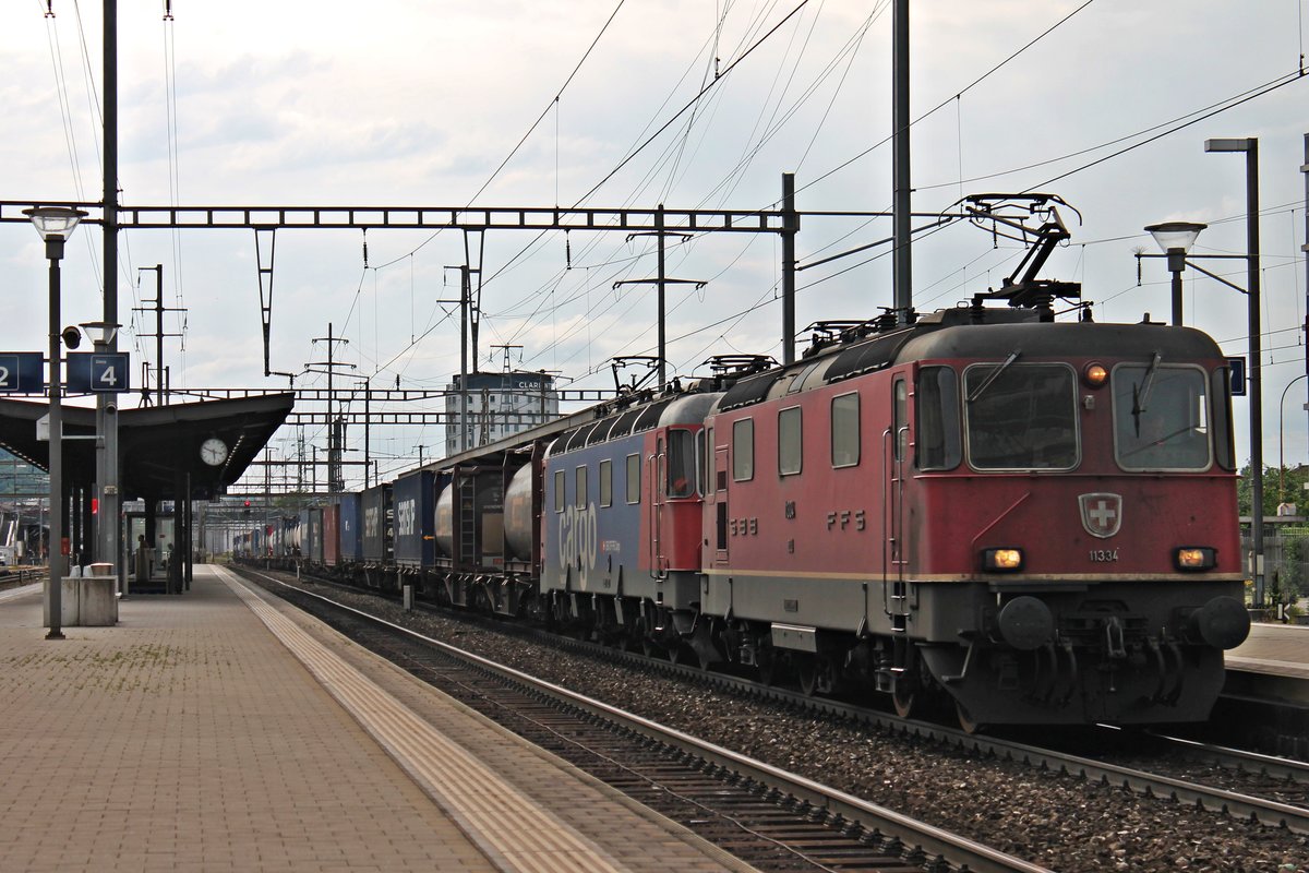 Am 14.05.2015 fuhren Re 4/4 II 11334 und Re 620 065-3  Ziegelbrücke  zusammen mit einem Containerzug aus Richtung Rangierbahnhof Muttenz kommend durch den Bahnhof von Pratteln gen Frick/Gotthard.