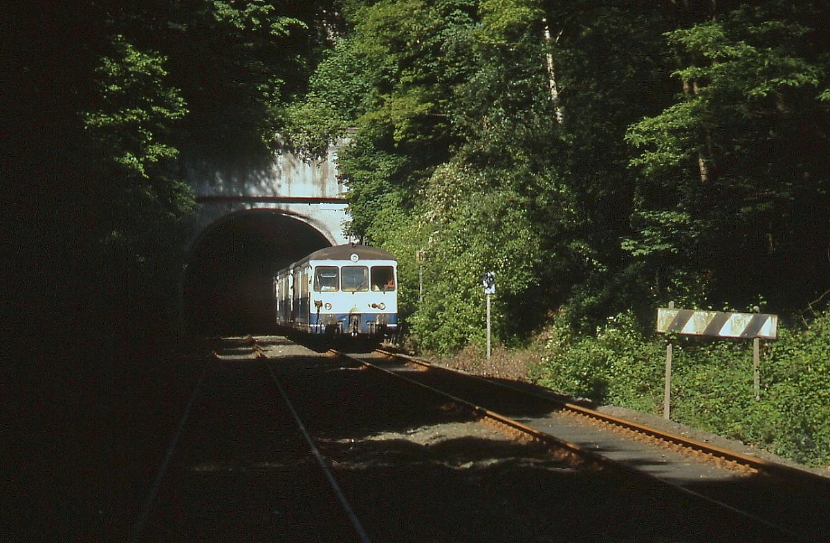 Am 16.05.1993 fand auf der Wuppertaler Nordbahn eine Sonderfahrt mit den Akkutriebwagen 515 604-7 und 515 690-3 und einem 815 statt. Der Personenverkehr war zu diesem Zeitpunkt bereits Geschichte. Da das südliche Streckengleis bereits nicht mehr befahrbar war, verkehrten die Triebwagen von Vohwinkel nach Wichlinghausen als  Falschfahrt . Das hatte wenigstens den Vorteil, dass bei Fotohalten und Scheinanfahrten Aufnahmen aus dem Gleis gemacht werden konnten. Hier hat der Sonderzug gerade den Dorp-Tunnel kurz vor dem Bahnhof Wuppertal-Ottenbruch verlassen. Nach der Einstellung des Güterverkehrs im Jahre 1999 wurde die Trasse zu einem Radweg umgebaut.