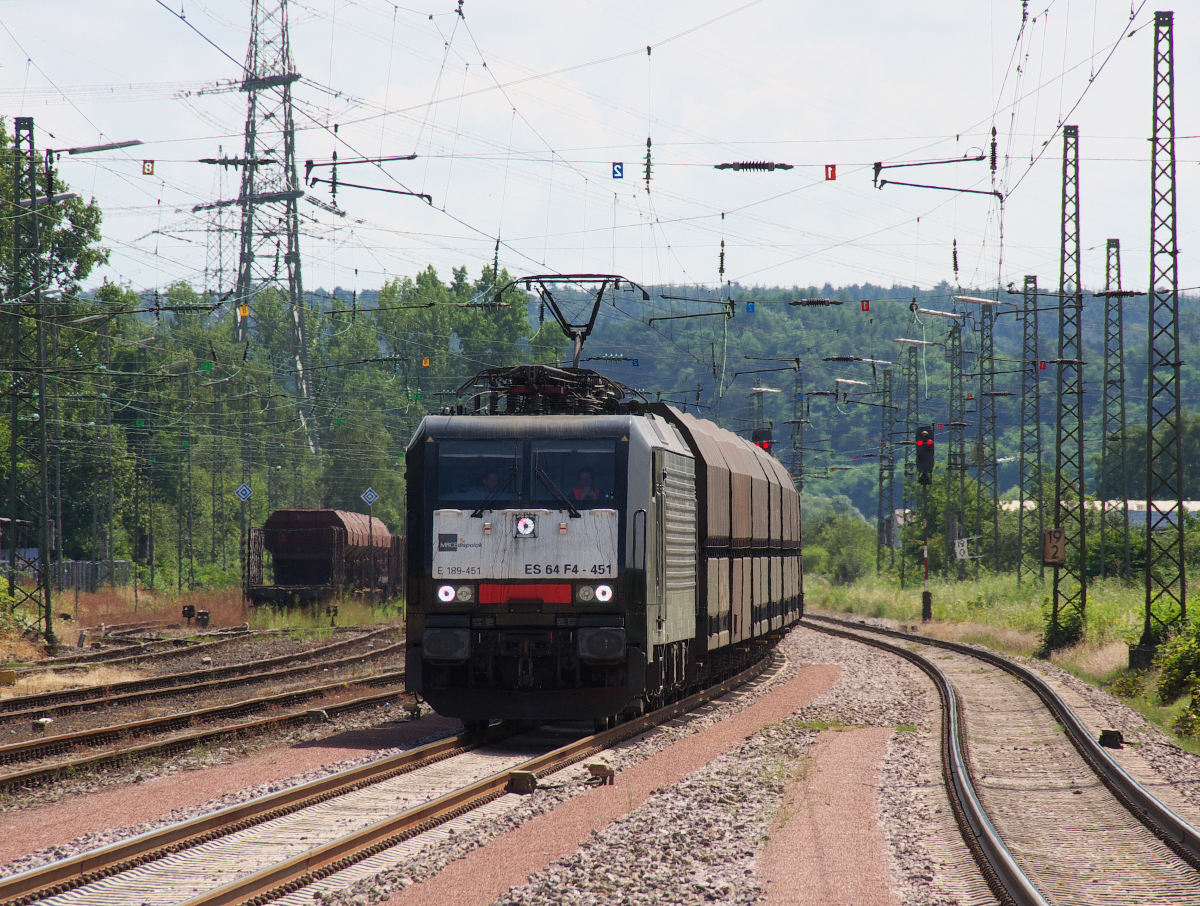 Am 26.07.2016 war ich nach Saarbrücken unterwegs und wartete auf meine Regionalbahn in Ensdorf Saar. Ein schönes Fotomotiv war auch noch drin. E 189 451 bringt einen leeren NIAG Kohlenzug zurück zum Duisburger Rheinhafen. 4 Kohle-Kraftwerke laufen noch im Saarland, drei werden mit der Bahn bedient. Im Hintergrund rechts liegt das KW Ensdorf, dieses wird meistens per Schiff bedient. Früher betrug die Fahrstrecke der Kraftwerkskohle vom Bergwerk Ensdorf bis zum KW knappe 2 Kilometer, heute legt die Kohle einige tausend Kilometer zurück. Verkehrte Welt oder Globalisierung nennt man das Heute. Bahnstrecke 3230 Saarbrücken - Karthaus
