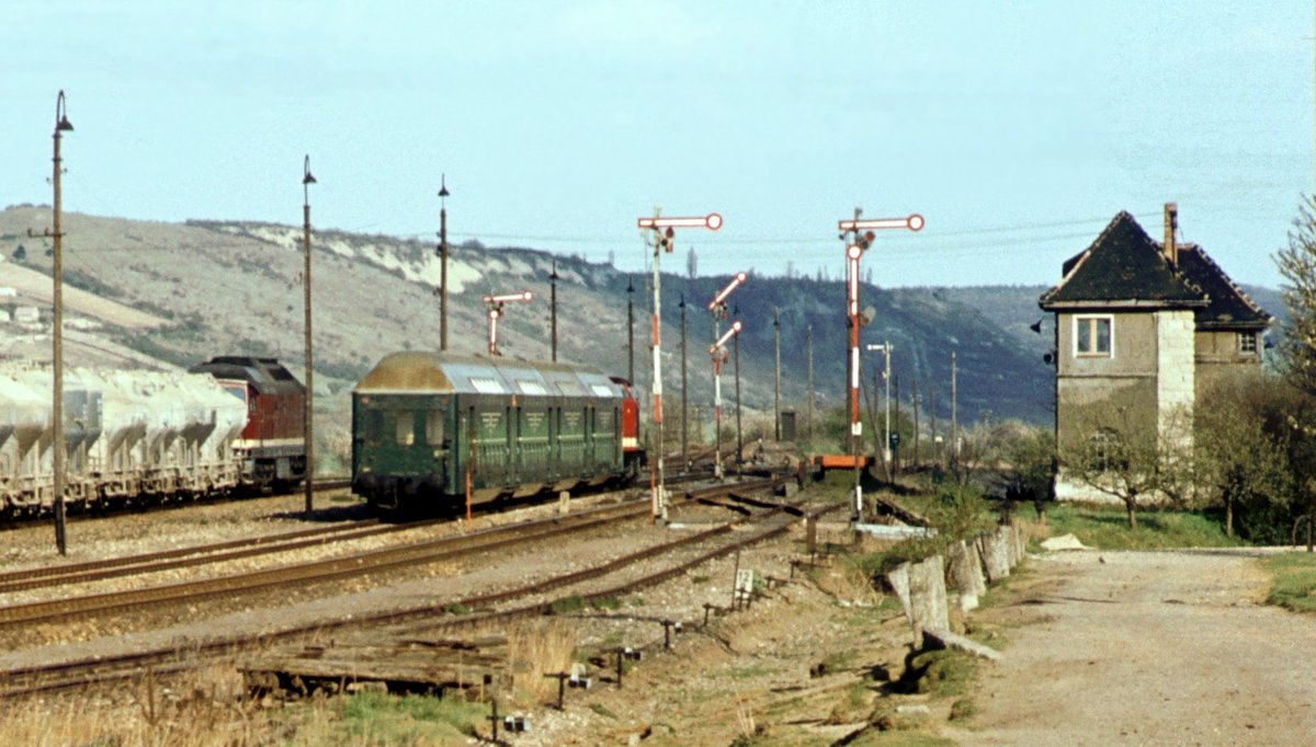 Am 27.04.1982 verlässt die DR 110 723-4 mit dem Leerzug des P 3573 aus Leuna Werke Süd den Bahnhof Laucha (Unstrut). Auf Gleis 5 steht ein Zementzug aus Karsdorf, der dem Doppelstockzug in Kürze in Richtung Naumburg (S) folgen wird. (Foto: Klaus Pollmächer †)