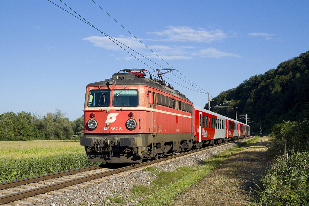 Am 29. Juli 2016 ist 1142 567 mit SB 4150 (Spielfeld-Straß - Graz Hbf) nahe des Murkraftwerks Spielfeld unterwegs.