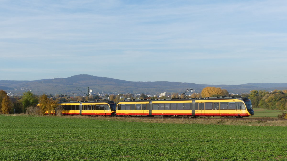 Am 3. November 2018 fanden auf der RB11 Frankfurt Höchst - Bad Soden Vorführungsfahrten mit einem AVG-Stadtbahntriebwagen statt. Damit sollte für das Projekt  Regionaltangente West , eine geplante Stadtbahnstrecke westlich von Frankfurt, geworben werden. Die beiden Triebwagen sind hier auf der Fahrt als RB11 nach Frankfurt Höchst zwischen Sulzbach und Sossenheim mit dem Taunus im Hintergrund zu sehen. Aufgenommen am 3.11.2018 15:49