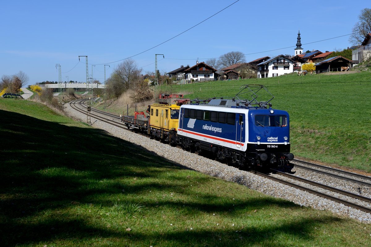 Am 30. März 2014 kam überraschend ein seltener Gast ins Chiemgau: Die national express 110 043 brachte Baugerät nach Freilassing. Bei Strass konnte der Exot abgelichtet werden. Hinter der Lok verbirgt sich übrigens die 1959 abgenommene 139 134, die 1985 in die 110 511 umgebaut wurde. Zuletzt war die Lok in weiß-roter Lackierung als Gewährleistungslok des DB Ausbesserungswerk Dessau im Einsatz.