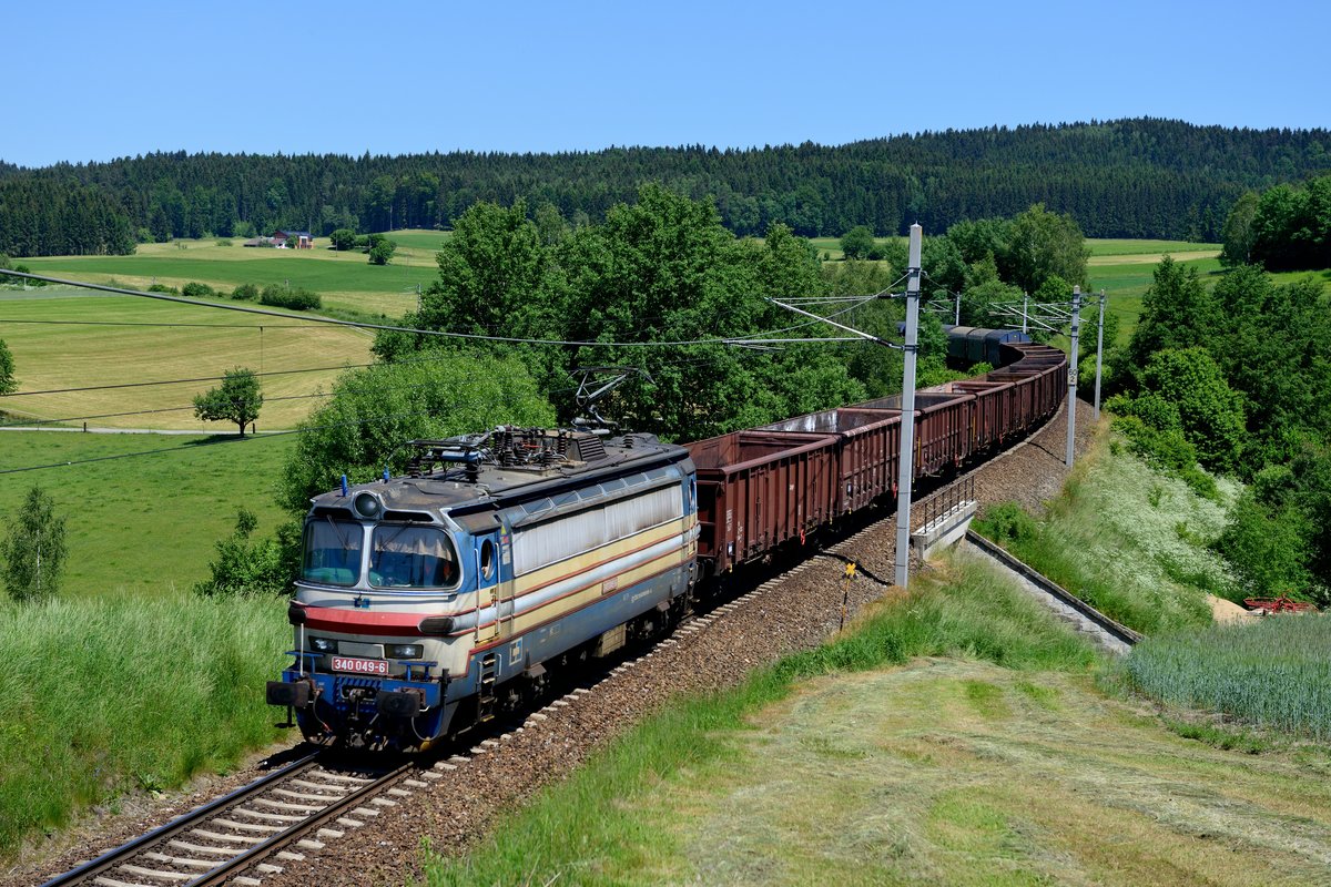 Am Morgen des 06. Juni 2015 wurde erneut der Fahrdienstleiter in Summenau aufgesucht und befragt, was denn so an Güterverkehr zu erwarten sei. Drei Güterzüge sollten aus Tschechien kommen, der Stahlzug, ein Autotransport und ein gemischter. An dieser Stelle ein herzliches Dankeschön an das freundliche und hilfsbereite Bahnpersonal der Region. Anschließend wurde zunächst bei Deutsch Hörschlag Position bezogen und schon relativ bald kam die Mehrsystem-Laminatka 340 049 mit dem leeren Stahlzug 47531 zur Voest Alpine nach Linz über die Grenze gerumpelt.