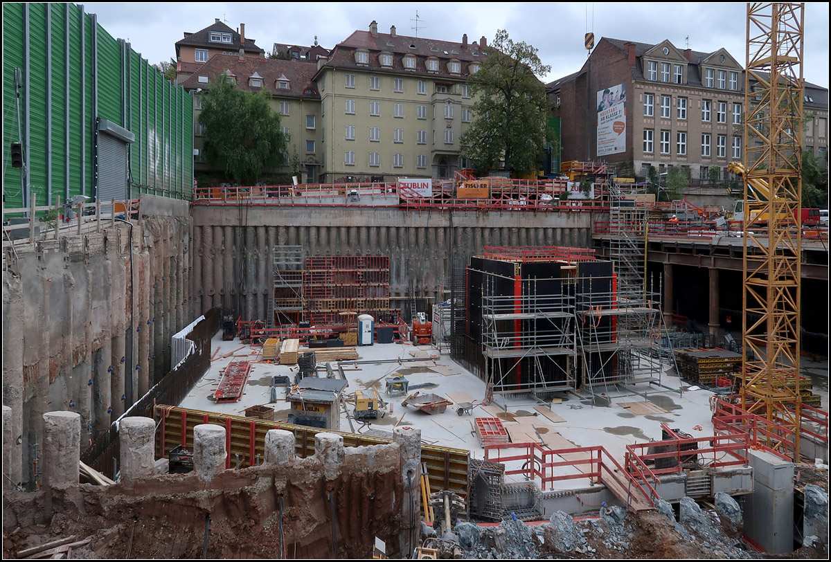 Am Südkopf des Stuttgarter Hauptbahnhofes -

... in Zukunft die Gleise aus dem Neckartal und von der Autobahn A8 auf den Fildern aus dem Berg kommen und an den unterirdischen Hauptbahnhof von Stuttgart anschließen. Die Gleisebene des Vorfeldes liegt unterhalb der unten sichtbaren Betondecke. Die beiden hier sich auf je drei Gleise aufweitenden Tunnelröhren werden tief unter den Gebäuden aufgefahren werden. Ab der Bohrpfahlwand im Hintergrund fehlen noch ca. 400 Meter Tunnel. Dahinter sind die Tunnels bis zum Neckar und und die ganze Stadtauswärts-Röhre des Filertunnels schon aufgefahren bzw. gebohrt. Über den zukünftigen Rettungszufahrtstunnel wurden die Tunnelstrecken auch von dieser Seite her aufgefahren. 

02.10.2018 (M)