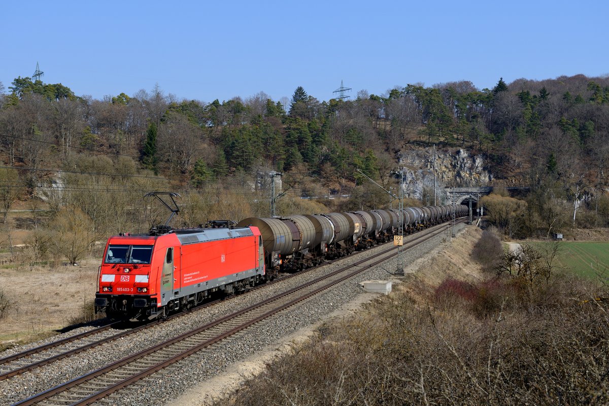 Auch DB Schenker mischt im Mineralöl-Verkehr von und zu den Raffinerien im Raum Ingolstadt mit. Am 20. März 2015 war die 185 403 mit einem Kesselwagen-Ganzzug in Richtung Treuchtlingen unterwegs. Beim Verlassen des 633 Meter langen Esslinger Tunnels konnte die Leistung fotografiert werden.