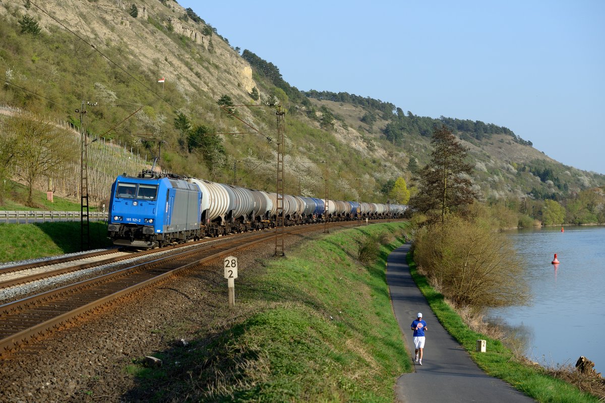 Auch die Privaten befördern Kesselzüge: So die HGK 185 521 am 02. April 2014, aufgenommen bei Gambach. Der Jogger hat sich übrigens freundlicherweise farblich zum Zug abgestimmt....