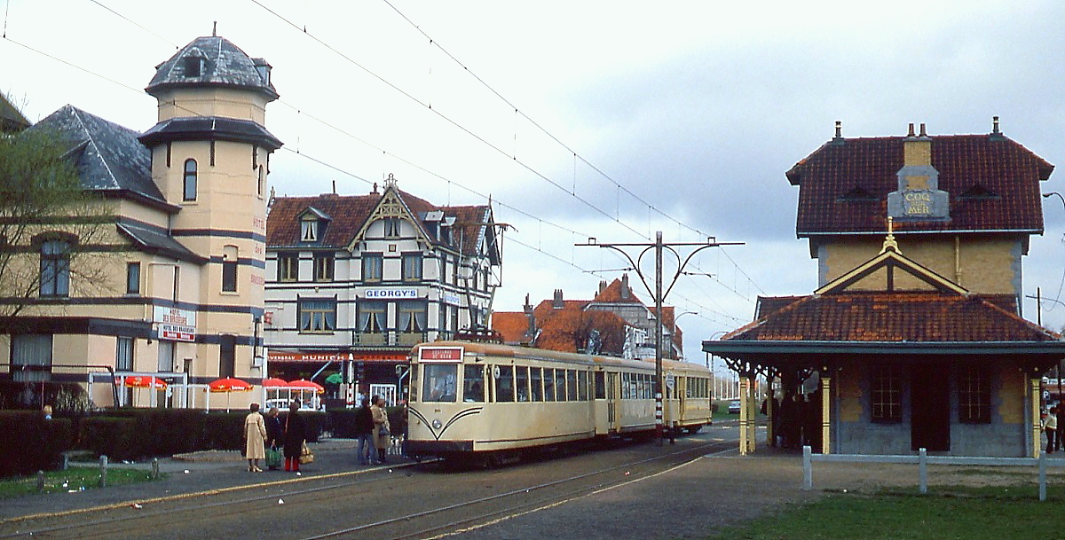 Auf dem Weg nach Knokke trifft ein Dreiwagenzug der Kusttram im Frühjahr 1979 in De Haan ein, rechts das schöne Bahnhofsgebäude