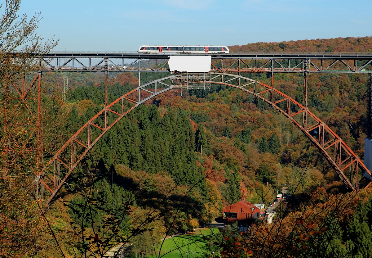 Auf dem Weg von Solingen Hbf. nach Wuppertal Hbf. fährt ein Alstom Coradia Lint 41/H von Abellio am 18.10.2017 über die Müngstener Brücke. Genau unter dem Triebwagen befindet sich die zur Abdeckung der Sandstrahlarbeiten angebrachte Plane. Nach Abschluß der Sanierungsarbeiten im kommenden Jahr wird sich die Brücke in Grau präsentieren, momentan passt sich der Brückenbogen den Herbstfarben des Waldes an.