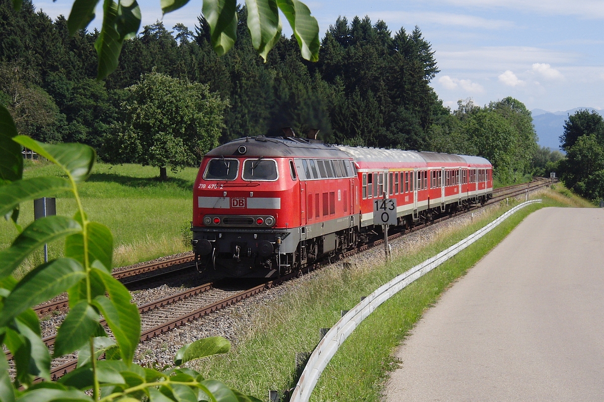 Auf der Fahrt von Lindau nach Augsburg schiebt bei Hhenreute 218 475-2 die Wagen der RB 57545 das Allgu hinauf (03.07.2011).