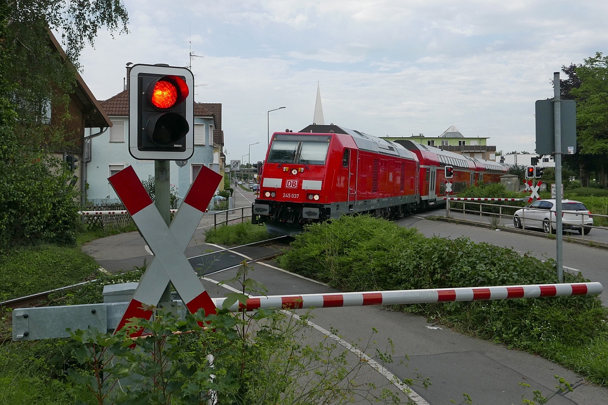 Auf der Fahrt von Lindau nach Stuttgart berquert 245 037 mit dem IRE 4232 in Friedrichshafen die Paulinenstrae und erreicht in Krze den Stadtbahnhof (31.07.2017)