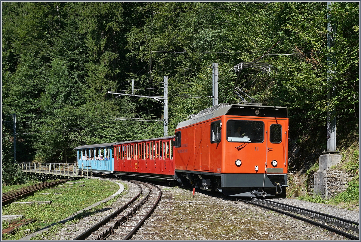 Aus Anlass des Jubiläums 125 Jahre Rocheres de Naye Bahn bietet die Zahnradbahn z.Z. täglich zwei Zugspaare unter dem Titel  La Belle Epoque fait son retour  an. Dieses Bild zeigt die He 2/2 11 mit dem talwärts fahrenden Zug (Rochers de Naye ab 16.11, Montreux an 17.10) bestehend aus den zwischen 1892 und 1909 gebauten Original-Wagen M-GL BC2 und BC 16 bei der Haltestelle le Tremblex. 14. August 2017 