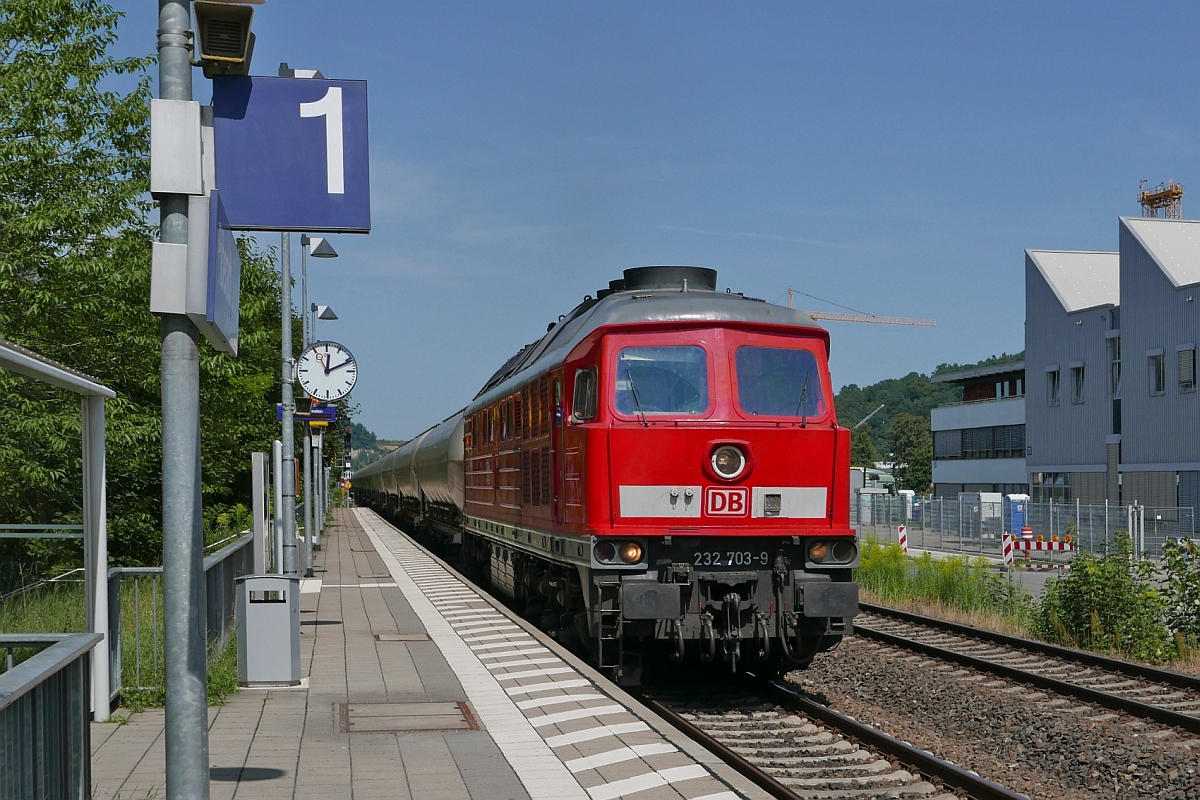 Aus Richtung Ulm kommend zieht 232 703-9 einen 'Rheintalbahn-Umleiter', einen aus Silowagen gebildeten Ganzzug, am 15.08.2017 durch die Haltestelle Biberach Sd.