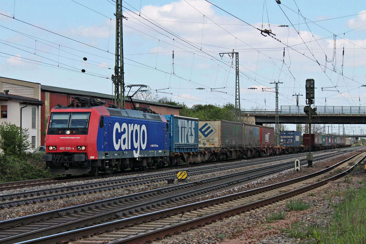 Ausfahrt am 18.04.2015 von Re 482 025-4 mit einem Containerzug aus dem Überholgleis in Müllheim (Baden) gen Süden.