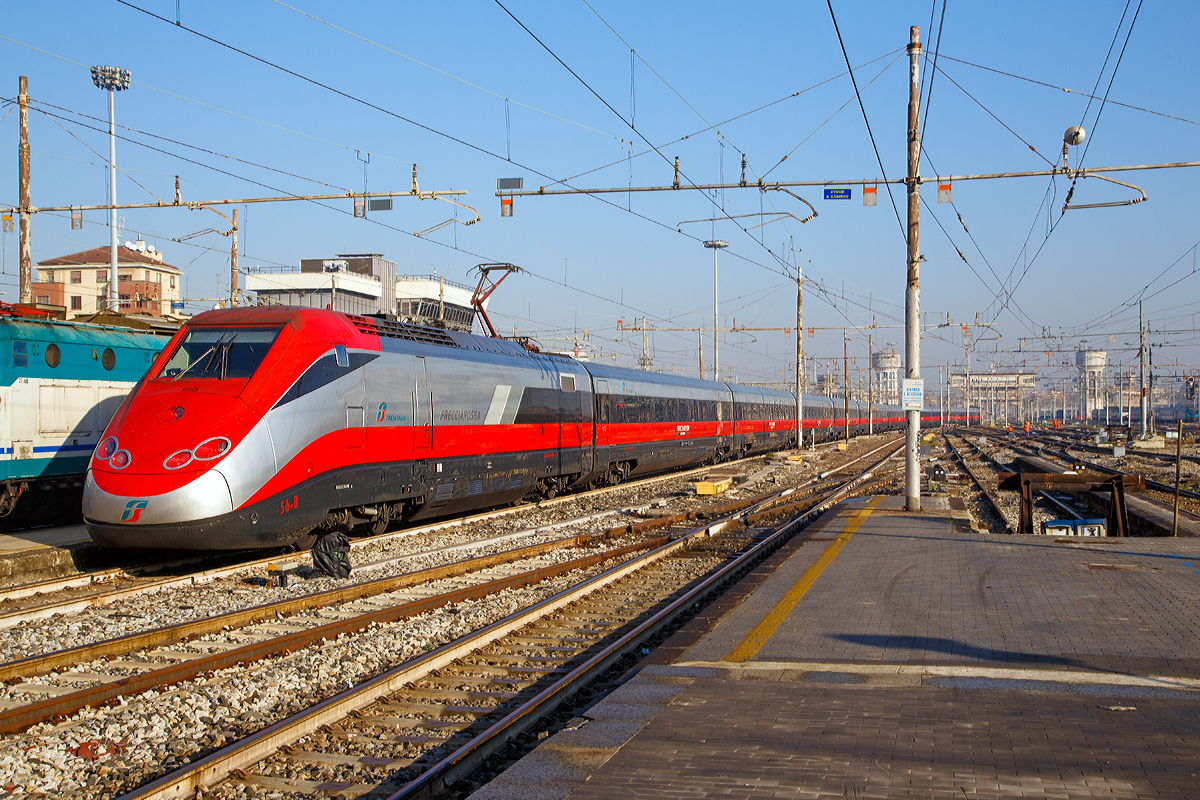 
Ausfahrt eines sehr langen  Frecciarossa  (deutsch: roter Pfeil) der Trenitalia (100-prozentige Tochtergesellschaft der Ferrovie dello Stato (FS)) am 29.12.2015 vom Bahnhof Milano Centrale (Mailand Zentral). 

Der Frecciarossa ist eine Zuggattung für Züge mit einer Höchstgeschwindigkeit von 300 km/h. Hier ist es der ETR 500 - 56 ein ETR 500 der 2.Serie. ETR steht ElettroTreno Rapido. 