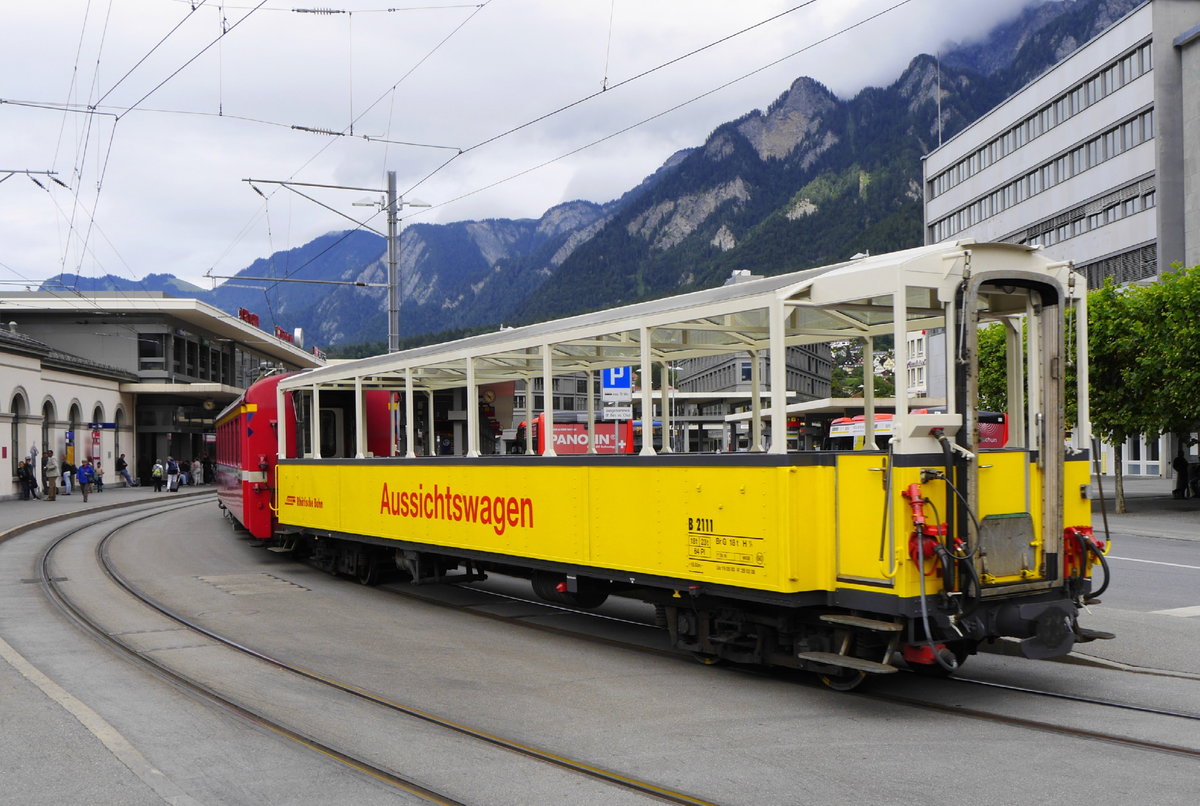 B 2111 heißt der offene Aussichtswagen, der werktags, wie man sieht auch bei schlechtem Wetter, auf der Arosabahn zum Einsatz kommt. Aufnahme auf dem Bahnhofsvorplatz Chur, 10.8.16.