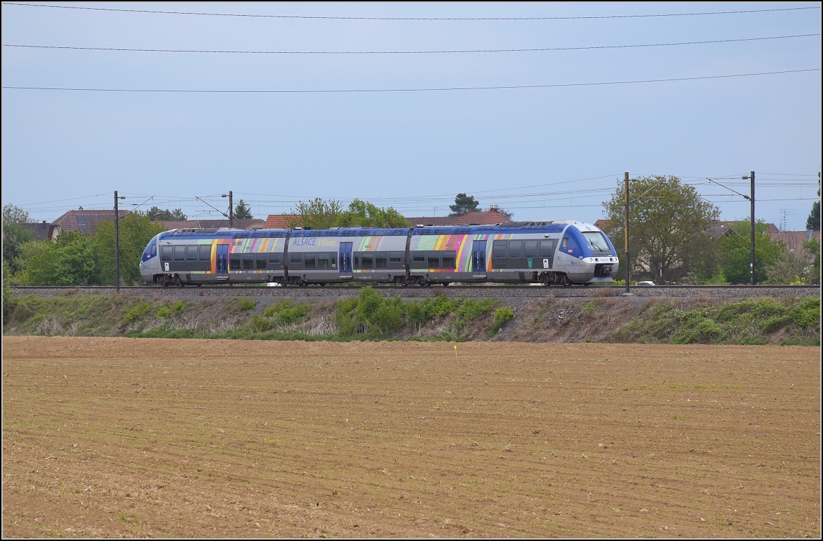 Bahn im Elsass. Bombardier ACG 76629 mit Dieselantrieb fhrt unter Fahrdraht an Raedersheim vorbei. April 2017.