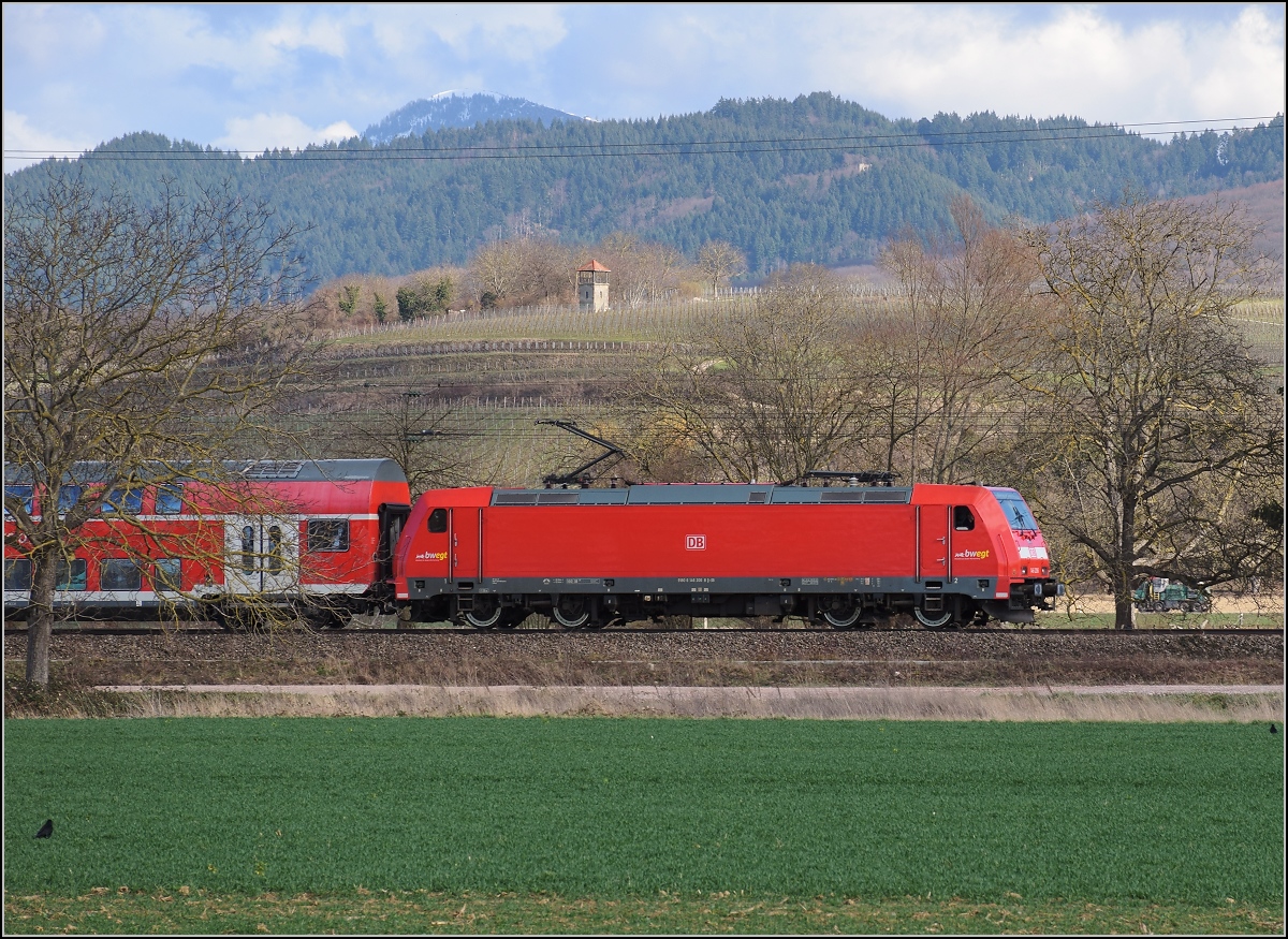 Bahn im Markgräfler Land. Regionalexpress nach Basel mit 146 206. Im Hintergrund das noch schneebedeckte Belchen, Müllheim, März 2019.