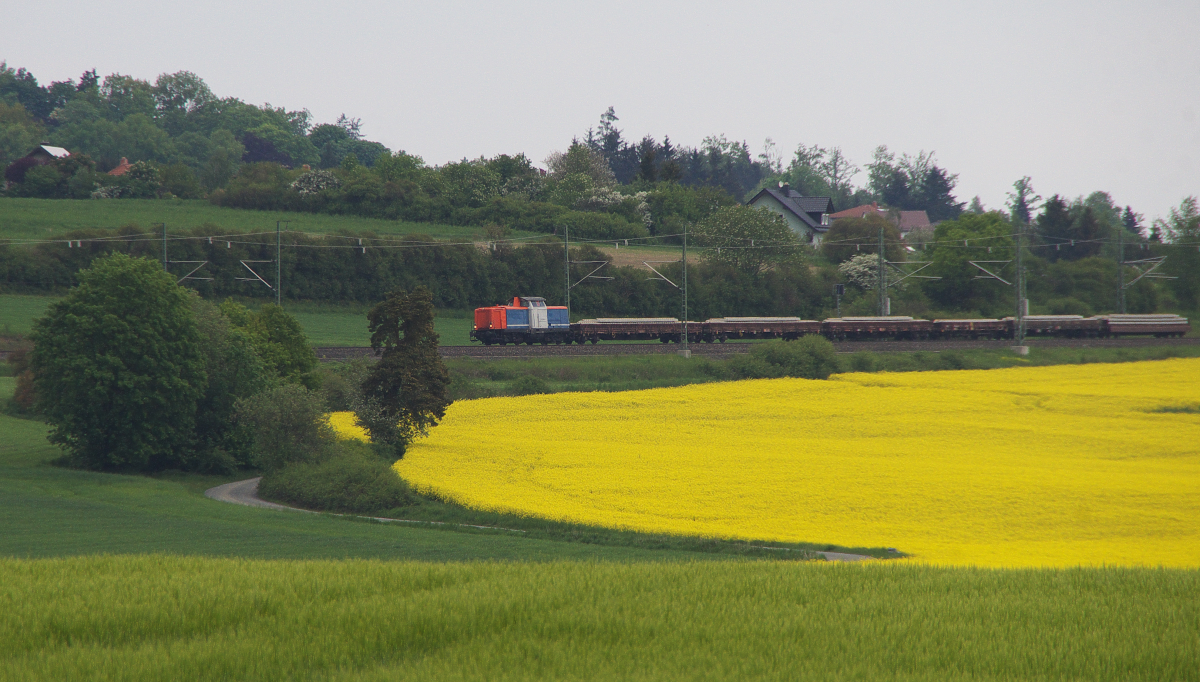 Bahnstreik II - Am 21 Mai 2015 blieben die meisten Personen- und Güterzüge aus dem DB Konzern auf den Abstellgleisen. Betrieb auf den Gleisen gab es dennoch. 212 063-2 rollt das Gefälle hinter Feilitzsch in Richtung Hof hinab. Noch eine Minute und der Zug mit neuen Schwellen und Gleisen wird direkt an uns vorbei rollen. Ich vermute die Fuhre geht nach Selb-Plößberg. Die Bahnstrecke 5027 Cheb (Eger) - As (Asch) - Selb-Plößberg - Oberkotzau bekommt den Lückenschluß zwischen Plößberg und As. Dann können wieder Züge zwischen Deutschland und Tschechien grenzüberschreitend fahren. 
212 063-2 wurde im Herbst 1963 von MaK mit der Bezeichnung V 100 2063 an die DB ausgeliefert. Neuerdings ist sie im Besitz von ALS - ALSTOM Lokomotiven Service GmbH, Stendal. Vermietung an SVG - Stauden-Verkehrs-GmbH. Bahnstrecke 6362 Leipzig - Hof