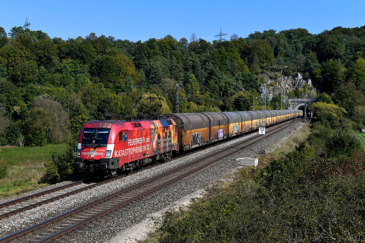 Bei der Ausfahrt aus dem Esslinger Tunnel konnte ich am 28. September 2018 die 1016.048 mit dem DGS 59760 von München Milbertshofen nach Bremen Rbf fotografieren. Die Lok mit ihrer auffälligen Werbung für den niederösterreichischen Feuerwehrverband ist aktuell praktisch nur noch innerdeutsch für RCC vor Autotransportzügen zwischen Süddeutschland und den Nordseehäfen unterwegs. 