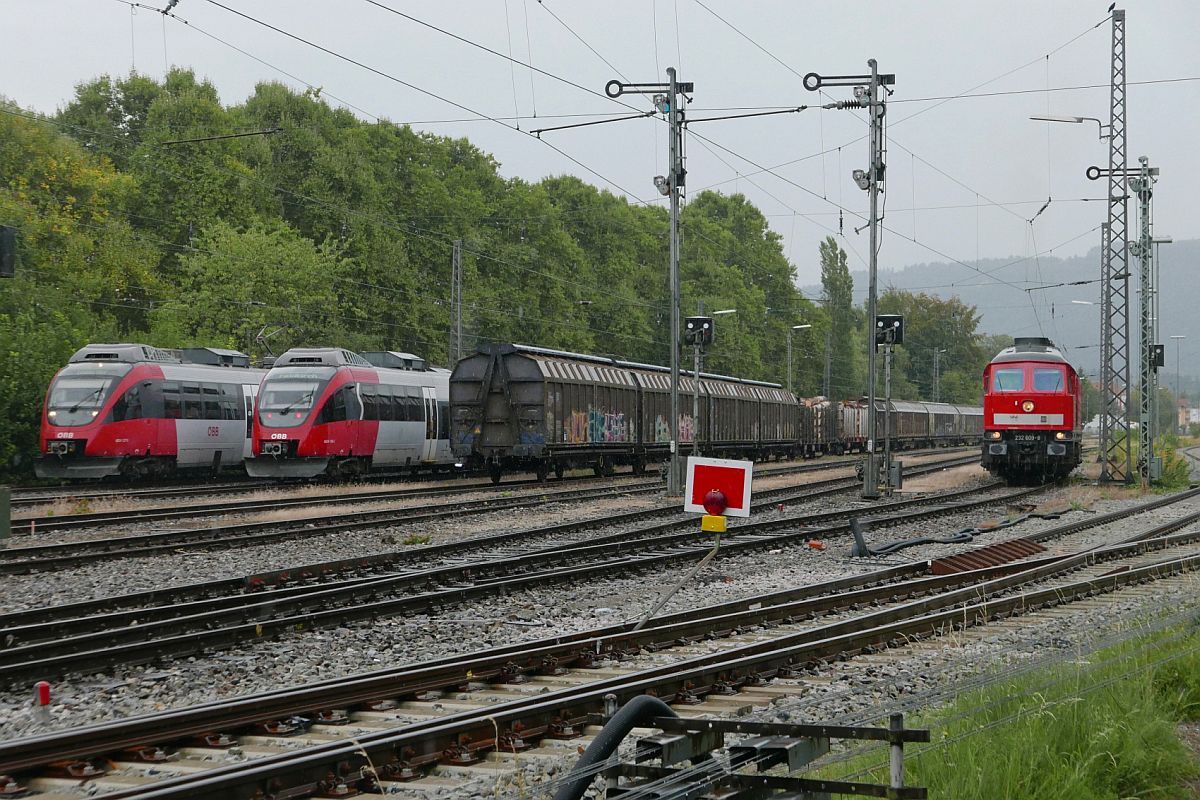 Bei starkem Regen begegnen in Lindau-Reutin die beiden Triebwagen von und nach Lindau der auf Streckenfreigabe wartenden 232 609-8, um die bereitgestellten Wagen des 'Arlberg-Umleiters' zu bernehmen (24.08.2018).