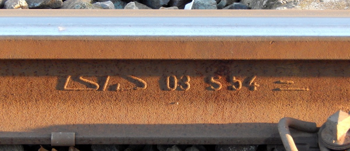 Beim warten meines zuges in Neuss lichtete ich dieses Schienenwalzzeichen ab. Hier wird gezeigt das TSTG der Hersteller der Schiene war, die Schiene 2003 gewalzt wurde, das es eine S54 (54 E4)Schiene ist und das die Schiene aus der Stahlsorte R260 Kohlenstoff-Mangan-Stahl besteht. So ein Walzzeichen sagt alles über die Schiene aus.

Neuss 26.11.2015