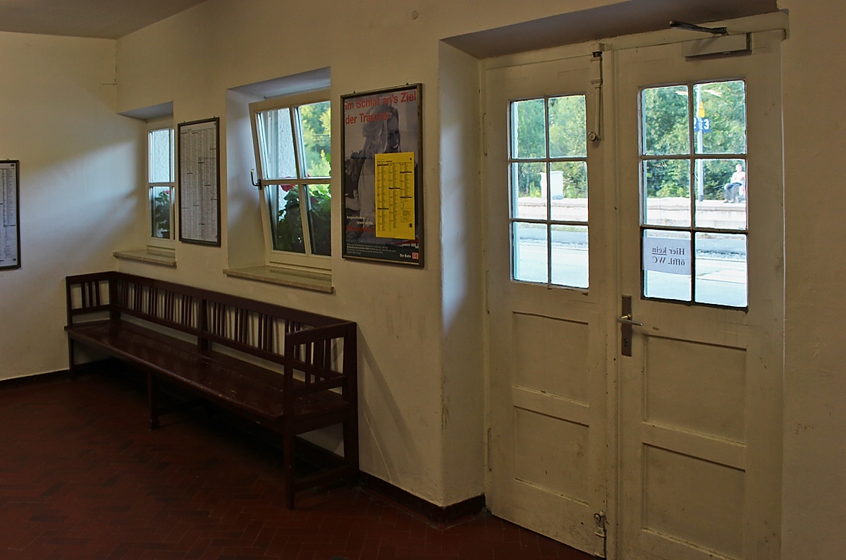 Blick auf die Eingangstür und eine Wartebank aus längst vergangener Zeit im Bahnhof Bayrischzell (10.08.2013)