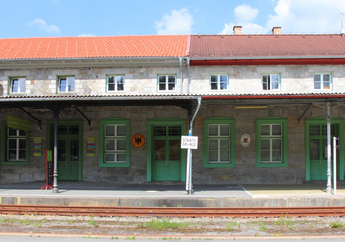 Blick auf das Empfangsgebäude des Bahnhofs Bayerisch Eisenstein am 18.08.2016. Die Staatsgrenze geht mitten durch das Empfangsgebäude, auf der linken Seite befindet sich Deutschland und rechts ist Tschechien.
