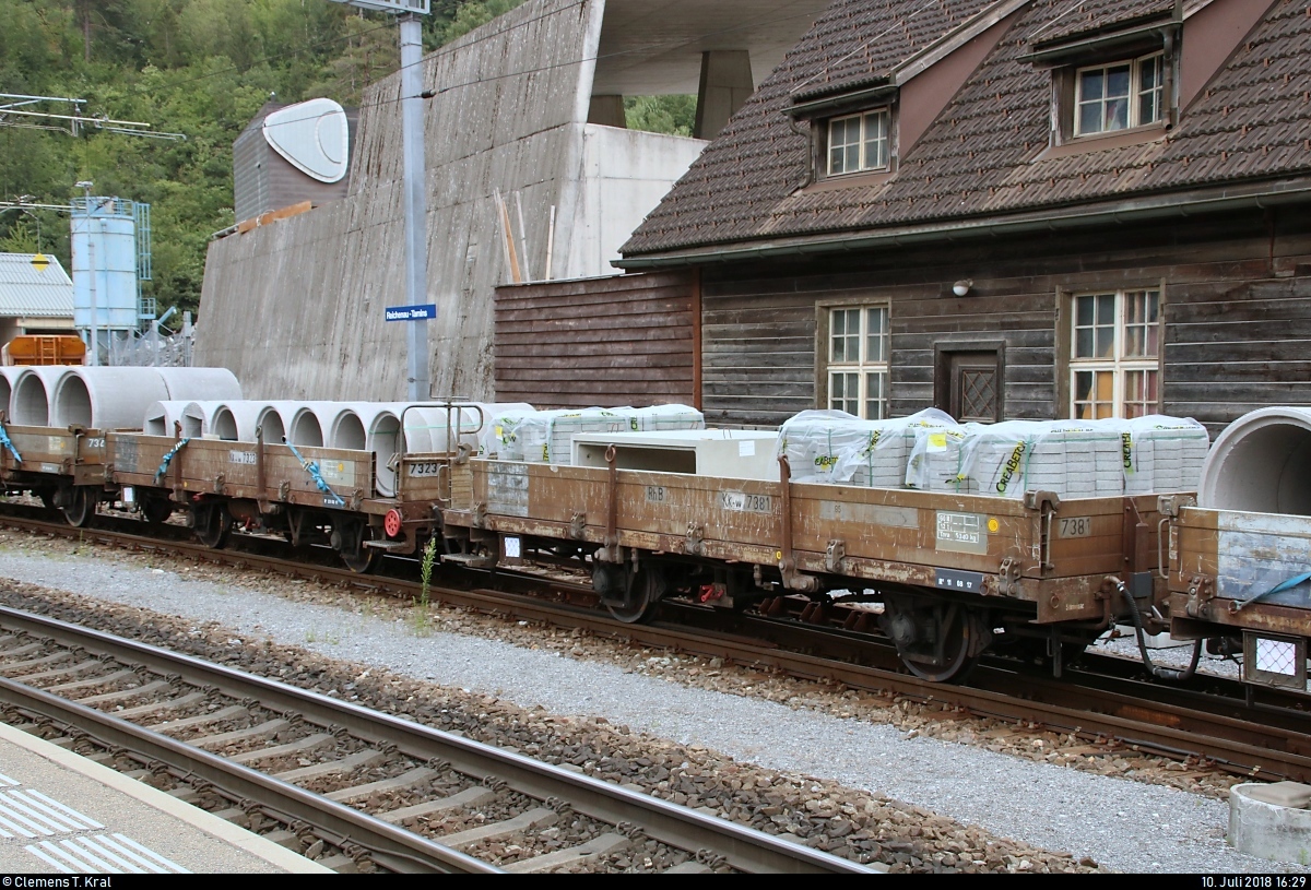Blick auf zwei Flachwagen der Gattung  Kk-w  (7323 und 7381) der Rhätischen Bahn (RhB), die in einem gemischten Gz mit Ge 6/6 II 703  St. Moritz  der Rhätischen Bahn (RhB) eingereiht sind und im Bahnhof Reichenau-Tamins (CH) stehen.
[10.7.2018 | 16:29 Uhr]