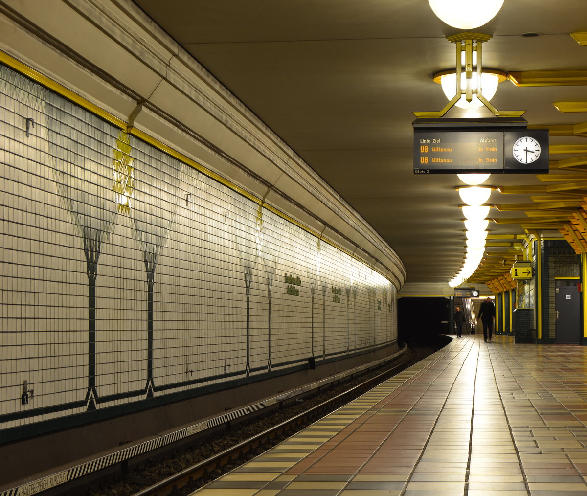 Blick durch die am 27. April 1987 eröffnete U-Bahn Station Franz Neumann Platz. 

An den Wänden sind Bäume und farbenfrohe Vögel dargestellt, der Bahnsteig ist in erdfarbenen Tönen gehalten. An den Mittelstützen sind gelbe Plastikschienen angebracht, die bis hin zur Decke führen, ebenso sind die länglichen Streifen an den Ecken grün verkleidet, sodass die Mittelstützen Bäume darstellen.

Berlin Reinikendorf 03.01.2018


Seite „U-Bahnhof Franz-Neumann-Platz (Am Schäfersee)“. In: Wikipedia, Die freie Enzyklopädie. Bearbeitungsstand: 8. August 2017, 20:10 UTC. URL: https://de.wikipedia.org/w/index.php?title=U-Bahnhof_Franz-Neumann-Platz_(Am_Sch%C3%A4fersee)&oldid=167987000