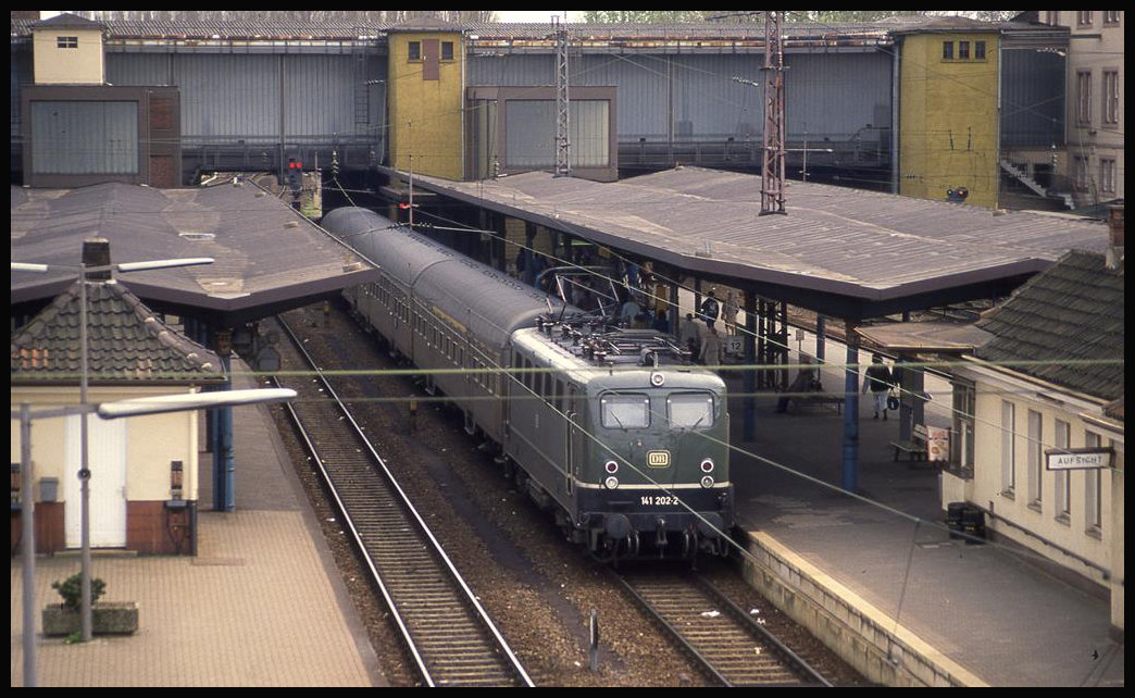 Blick von der Fußgängerbrücke im HBF Osnabrück auf den unteren Bahnhof und den dahinter verdeckt liegenden oberen Bereich. Gerade ist im unteren Teil am 21.4.1992 um 14.08 Uhr der Eilzug aus Paderborn mit 141202 angekommen.