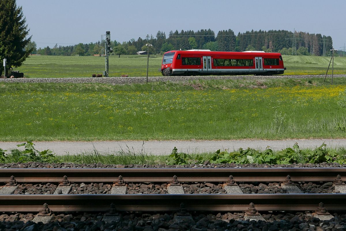 Blick ber ein Gleis der Bayerischen Allgubahn auf die Wrttembergische Allgubahn, auf der RB 22831 von Aulendorf nach Lindau fhrt und sich kurz vor dem Bahnhof von Hergatz befindet (06.05.2018).