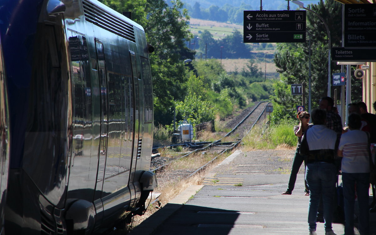 Blick zurück auf die Strecke der Cevennenbahn. TER73990 (Nimes - Clermont-Ferrand) ist soeben in Langogne angekommen und wird gleich weiter fahren. Zu sehen ist  X73699, links nur angeschnitten befindet sich X73677.
Langogne, 17. Juli 2016