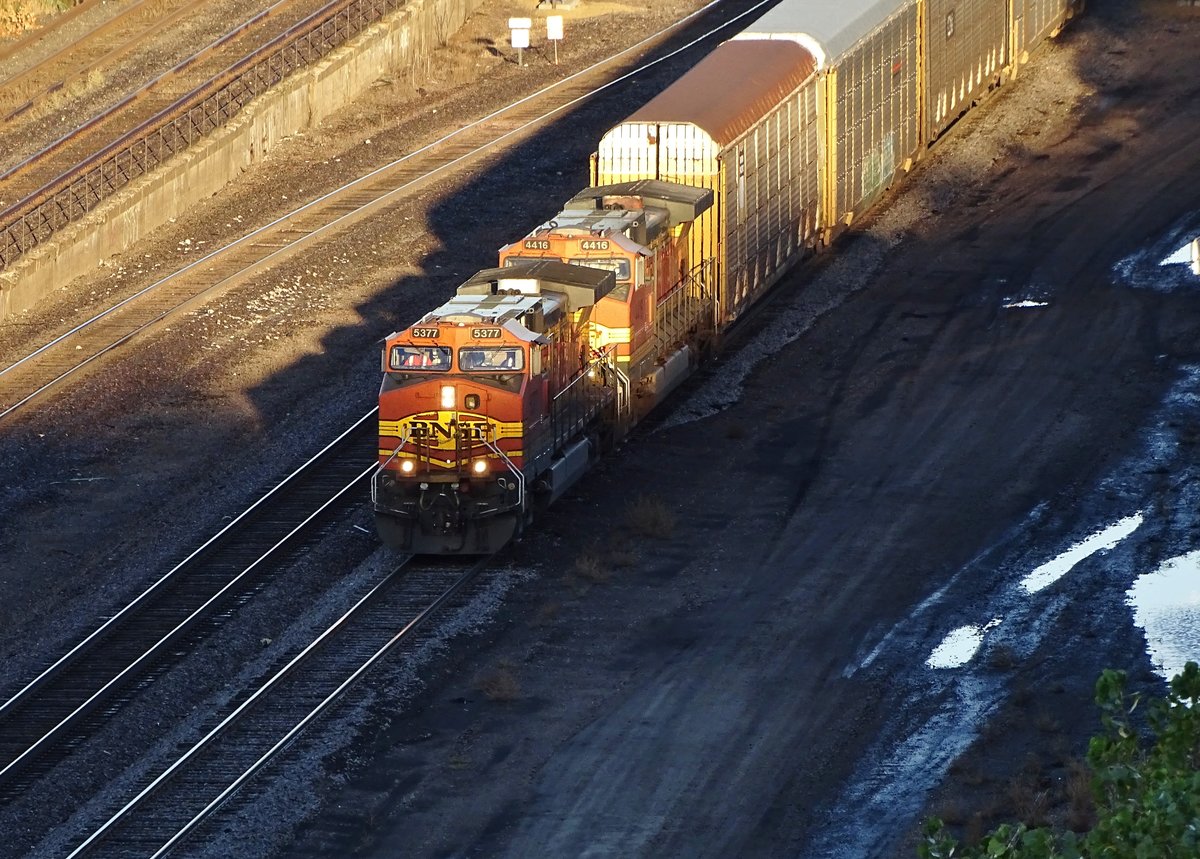 BNSF 5377 und 4416 beide GE C44-9W ziehen einen Autozug entlang des Mississippi nach Süden.Aufnahmeort Division Street Interlocking in Saint Paul,Minnesota,4.Okt.2017