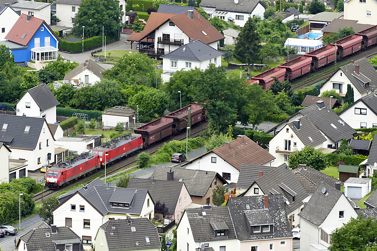 BR 185 Doppeltraktion mit Schüttgutwagen, ca. 100 m unter dem Rheinfelsen Erpeler Ley mitten durch Erpel am Rhein - 23-06-2018